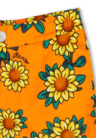 Oranje shorts met een zonnebloem patroon, met gele bloemblaadjes, bruine harten en groene bladeren. Inclusief een metalen knop en gestikte details.