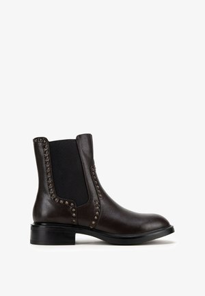 Dunkelbrauner Leder-Stiefelette mit schwarzem elastischem Seiteneinsatz und dekorativen runden Metallnieten entlang der Kanten, niedriger schwarzer Absatz.