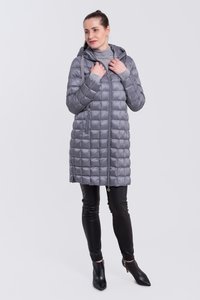 Abrigo acolchado gris con capucha, con cierre de cremallera en la parte delantera, bolsillos laterales y puños de canalé, combinado con pantalones de cuero negros y botines.