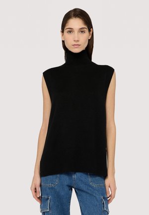 Czarny dzianinowy bezrękawnik z kołnierzem typu golf, o prążkowanej teksturze, z luźnym krojem i rozcięciami po bokach. Nosi się go z niebieskimi dżinsowymi spodniami cargo.