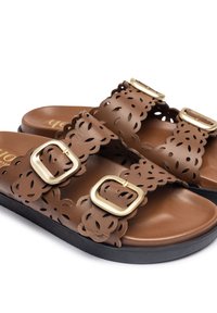 Sandales en cuir marron avec bords festonnés, motifs floraux découpés au laser, deux brides à boucle dorée et semelles noires.