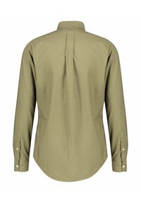 Zielona koszula z długim rękawem, z klasycznym kołnierzem, plisą z tyłu, mankietami na guziki oraz zaokrąglonym dołem, nadającym strukturę. Miękka bawełniana faktura.