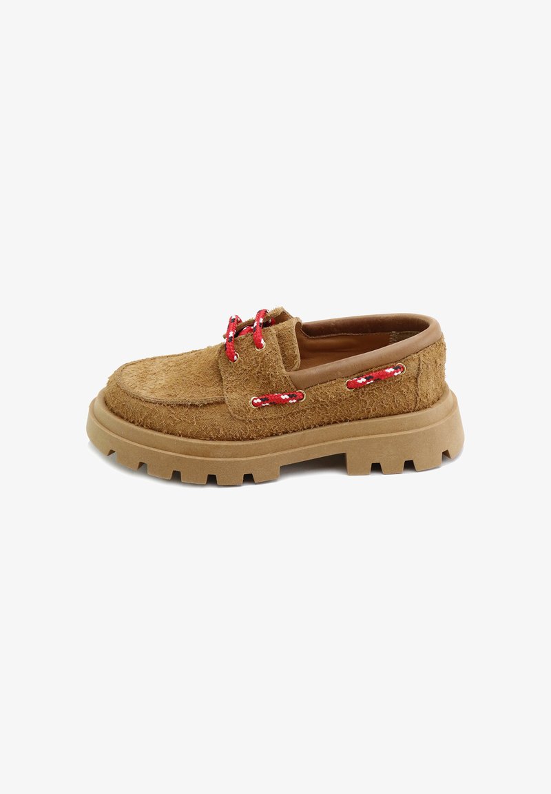 Zapato marrón, texturizado, con suela gruesa y cordones rojos. Presenta una parte superior suave y peluda, y una suela de goma con tacos para el agarre.