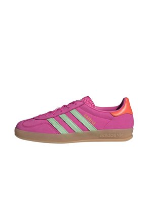 Jasnoróżowy but sportowy Adidas Gazelle z miętowozielonymi paskami, pomarańczową patką na pięcie i gumową podeszwą, przedstawiony w widoku z prawej strony.