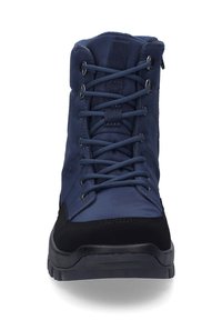 Botas de media caña azul marino con parte superior de tejido suave, acentos de ante negro, punta redonda y cierre de cordones. Suela de goma duradera con una textura en la banda.