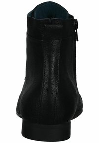 Stivale alla caviglia in pelle nera con texture liscia, punta arrotondata e zip laterale. Presenta un tacco basso e solido con una fodera interna a contrasto.
