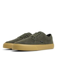 Tenisi verzi din suede cu vârf rotund, talpă din cauciuc bej în contrast și design cu șase orificii pentru șireturi. Detalii de brand minime prezente.