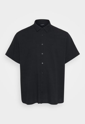 Camisa de botones de manga corta en color negro hecha de una tela texturada, con cuello y botones frontales, que presenta un corte relajado.
