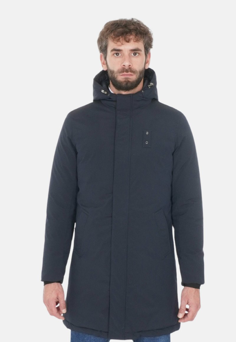 Parka blu navy con zip frontale, due tasche laterali e cappuccio. Realizzata in tessuto liscio e imbottito con una finitura leggermente testurizzata.