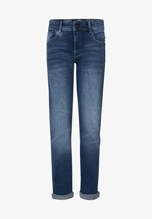 Jeans in denim blu scuro con taglio slim, caratterizzati da leggeri segni di usura e design a cinque tasche, abbinati a sneaker sportive grigie e bianche.