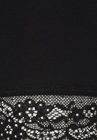 Czarna tkanina z falistą koronkową lamówką ozdobioną kwiatowymi i geometrycznymi wzorami wzdłuż krawędzi.