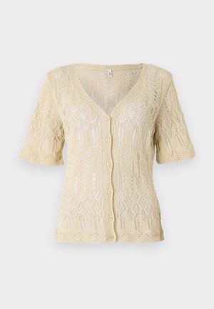 Cardigan tricoté en beige doux avec un col en V, des manches courtes et une fermeture à boutons. Présente des motifs en dentelle complexes et un tissu texturé.