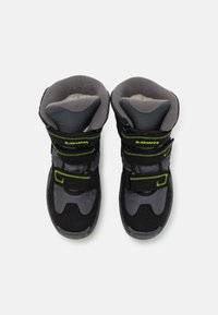 Stivali mid-top neri e grigi con tomaia in materiale sintetico e rivestimento morbido, dotati di doppie cinghie regolabili e dettagli verde brillante.