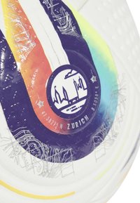 Barevný sportovní míč s lesklým povrchem, zdobený fialovým emblémem, grafikou městské krajiny a texturovanými vzory.