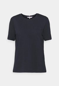Tmavě modré tričko vyrobené z bavlny, s kulatým výstřihem, krátkými rukávy a malým, třpytivým logem na hrudi. Hladká textura.