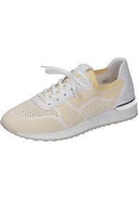 Lehká teniska s krémovým síťovaným svrškem, bílými tkaničkami a detaily. Má bílou podrážku a kovově stříbrný akcent na patě.