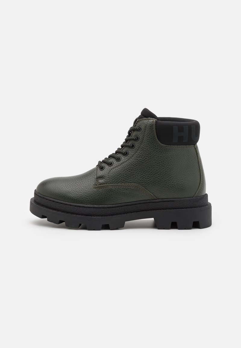 Bottine en cuir vert foncé avec col rembourré noir, lacets noirs et épaisse semelle crantée noire.
