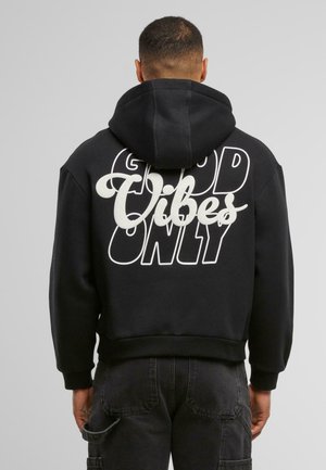 Schwarzer Hoodie mit einem großen weißen Grafikaufdruck, der "NUR GUTE VIBES" zeigt. Ausgestattet mit einer geräumigen Kapuze und gerippten Bündchen.