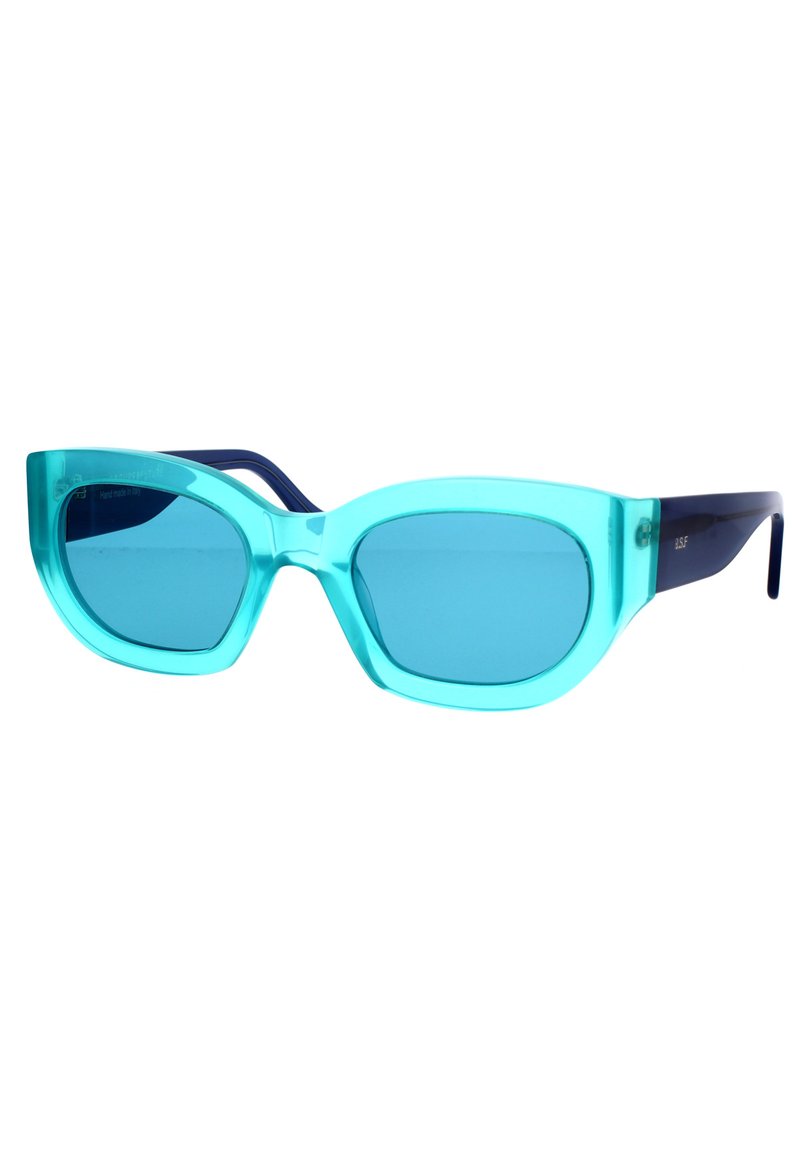 Un paio di occhiali da sole a occhio di gatto con montatura in acrilico traslucido color aqua e lenti blu. Le stecche sono di un blu navy scuro.
