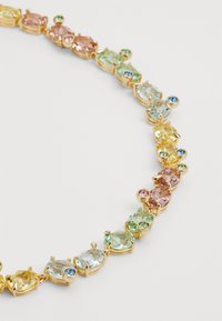 Gold-tone necklace featuring an alternating pattern of oval and round multicolored gemstones, including pink, green, blue, and yellow.