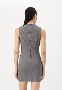 Grå denimkjole med en tettsittende silhuett, utringet design, glidelås i ryggen og minimale sømdetaljer. Glatt tekstur.