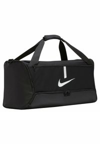 Zwarte sporttas gemaakt van duurzaam nylon, met een groot hoofdcompartiment, bovenste rits en contrasterend wit Nike-logo aan de zijkant.
