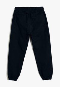 Schwarze Baumwoll-Jogginghosen mit elastischem Bund und Bündchen, ausgestattet mit zwei Gesäßtaschen und einem lässigen Schnitt für zusätzlichen Komfort.
