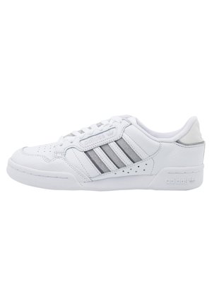 Hvid Adidas lavtop-sneaker med grå striber, perforeret tå, polstret krave og mærket sål og sidepanel.