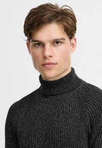 Dunkelgrauer gerippter Rollkragenpullover aus strukturiertem Strickmaterial, mit einem enganliegenden Kragen und nahtlosen Schultern.
