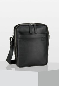 Borsa a tracolla nera in pelle con chiusura a zip, tasca frontale, tracolla regolabile e texture liscia. Design rettangolare minimalista con branding discreto.