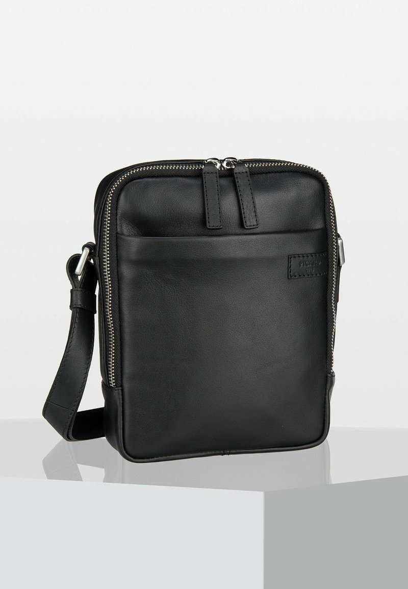Borsa a tracolla nera in pelle con chiusura a zip, tasca frontale, tracolla regolabile e texture liscia. Design rettangolare minimalista con branding discreto.