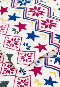 Tessuto di cotone con un motivo geometrico colorato, che presenta motivi rossi, blu, verdi e gialli tra cui stelle e fiocchi di neve su uno sfondo bianco.