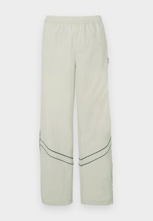 Hellgrüne, locker sitzende Hose mit elastischem Bund, versehen mit dunkelgrünen diagonalen Linien und einfachem Design. Glatter, leichter Stoff.