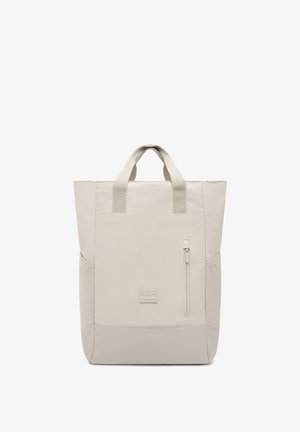 Beżowa torba na ramię z podwójnymi uchwytami, teksturowaną powierzchnią, przednią kieszenią na zamek oraz kwadratowym kształtem. Posiada małą metkę z logo z przodu.