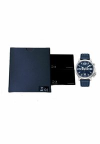 Mörkblå klocka med silverdetaljer, gummirem och stor urtavla som visar siffror och "POLICE." Levereras med en svart låda och kort.