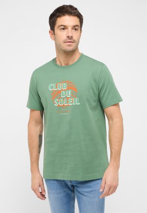 Light green cotton t-shirt with short sleeves and round neckline. Front features "CLUB DU SOLEIL" graphic in white and orange.