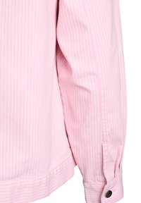 Roza majica z dolgimi rokavi, okrašena z navpičnimi belimi črtami, zapenjanimi manšetami in mehko teksturo z gladkim zaključkom.