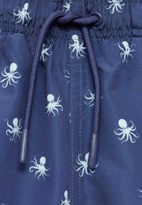 Námořnické plavky se vzorem opakujících se bílých chobotnic, mají stahovací pás a hladkou texturu. Doplňky zahrnují plastové špičky na stahovací šňůrce.