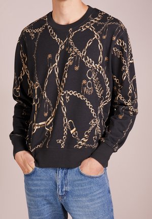 Black sweatshirt with gold chain and safety pin print, crew neckline, ribbed cuffs, and hem. Made of soft, textured fabric.