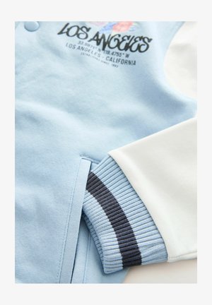 Lyseblå sweatshirt med hvide detaljer, der har ribbede cuffs med marineblå striber, og et grafisk print foran med teksten "Los Angeles, Californien."