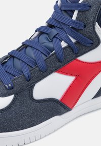 Sneaker blu in suede con accenti rossi e bianchi, realizzato in materiale testurizzato, con lacci rotondi e suola bianca.