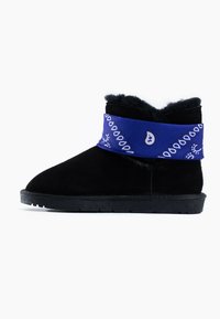 Botín negro de ante con un acento de estilo bandana azul alrededor de la parte superior, forro de piel sintética y suela de goma. Textura suave, punta redondeada.