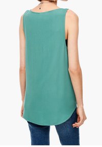 Blusa sin mangas verde con dobladillo curvado, fabricada en un tejido ligero y de textura suave. La parte trasera presenta un ajuste relajado y un diseño limpio.