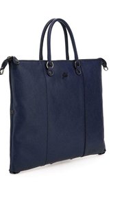 Sac fourre-tout en cuir bleu marine avec deux poignées, surface texturée, fermeture éclair et accent logo. Comprend des éléments en métal et une base arrondie.