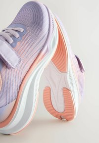 Chaussures de sport légères en dégradé violet et rose. Tige texturée avec des lignes parallèles et une semelle blanche rembourrée dotée d'un profil en caoutchouc.