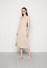 Vestido midi riscado nas cores verde, rosa e branco, feito de tecido suave. Apresenta alças ajustáveis, corte reto e uma silhueta de comprimento intermédio.