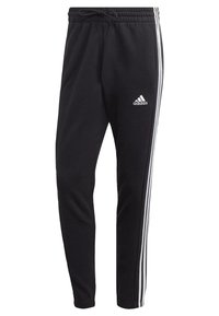 Svarta joggerbyxor i mjukt material, med vita tre-strimmor längs sidorna och en elastisk midja med dragsko.