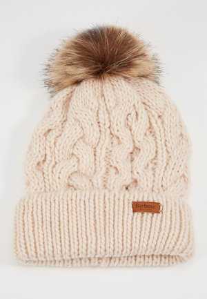 Bonnet d'hiver beige tricoté avec motif torsadé et bord plié, avec un pompon en fausse fourrure marron et une petite étiquette de la marque Barbour.