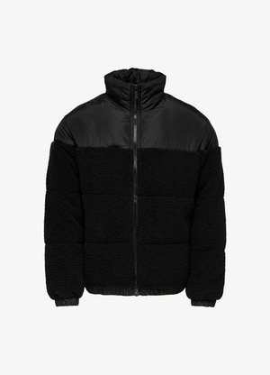 Veste noire avec un mélange de tissus lisses et texturés, un col haut et des poignets élastiques. Une fermeture éclair court sur l'avant.