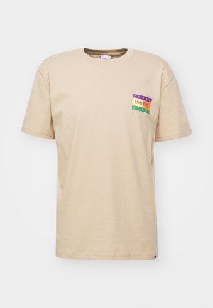 Beige T-shirt met korte mouwen met een klein kleurrijk Tommy Jeans-logo op de linkerborst en een klein logolabel vlak bij de onderzoom.